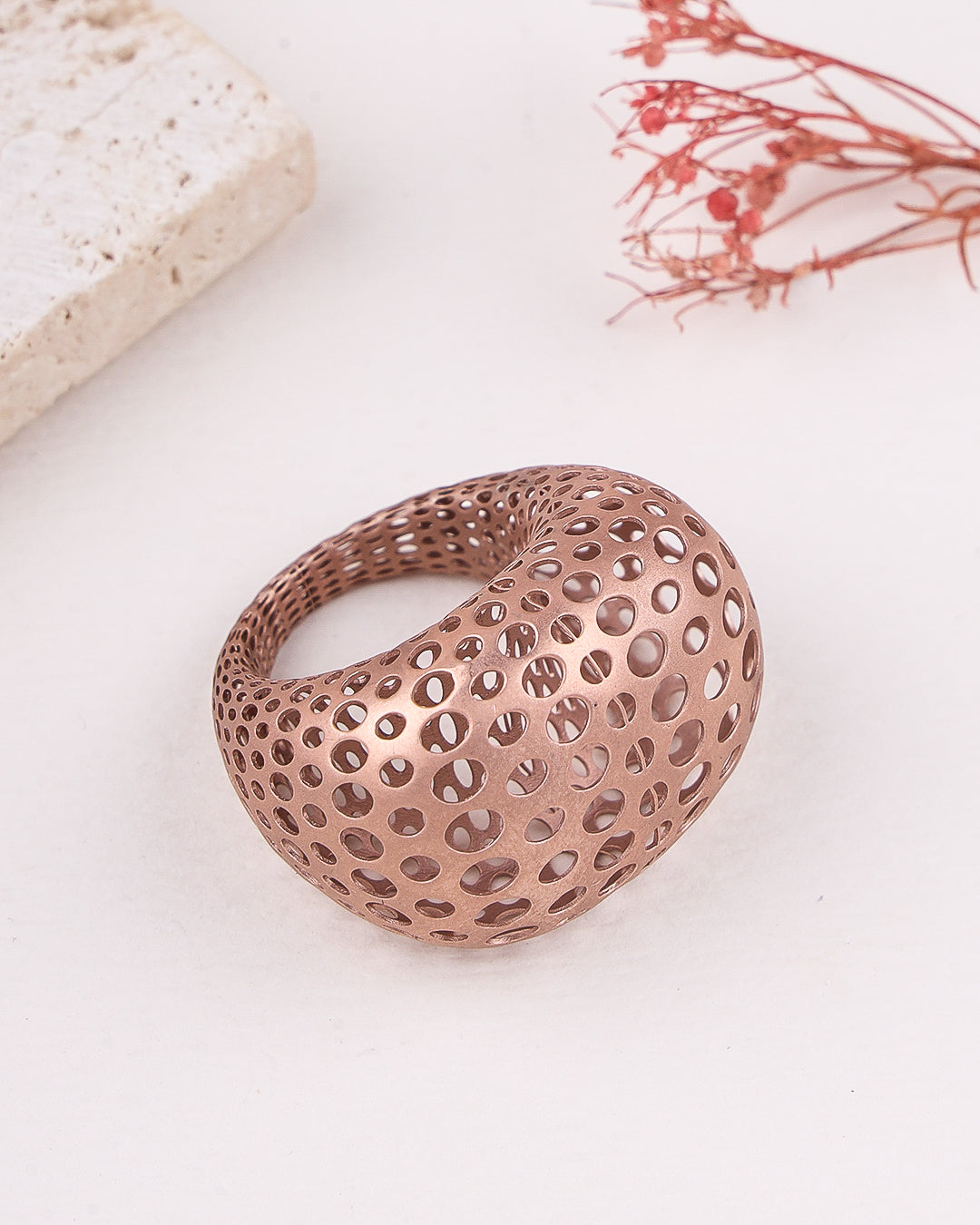 matte rose gold ring with a unique design on a light background
