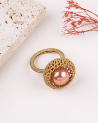 Gold ring with a pink pearl on a light background