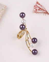 Gold ring with purple and white pearls on a light background
