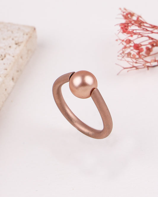 Rose gold ring with a pearl on a light background