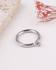 Silver ring with a small diamond on a light background