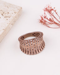 matte rose gold ring with intricate design on a light background