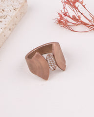 Rose gold ring with a textured band and embedded stones on a light background
