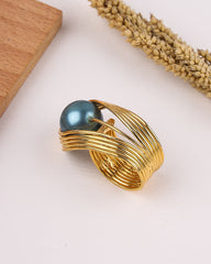 Gold ring with a blue gemstone on a light background