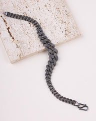 Black rhodium bracelet on a light stone surface