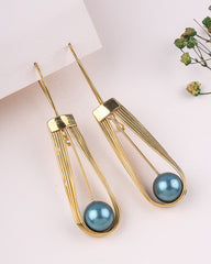 Gold earrings with blue spherical beads on a light background