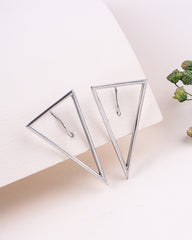 Silver triangle earrings on a white surface with a minimal background