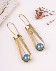 Gold earrings with blue spherical beads on a light background