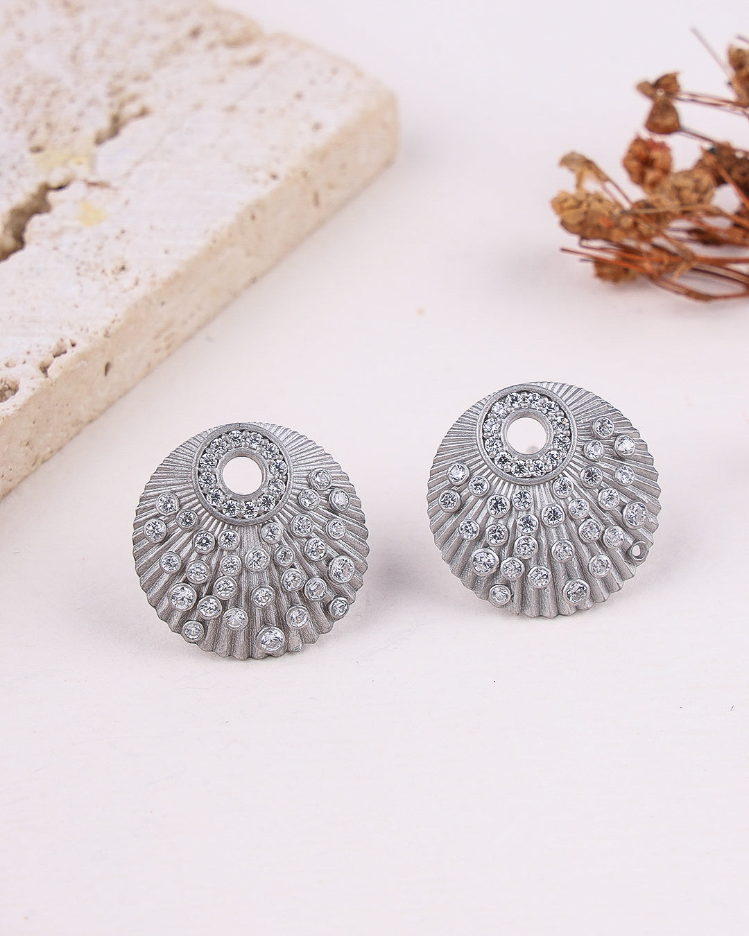 Silver earrings with gemstones on a light background