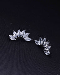 Pair of silver leaf-shaped earrings on a black background