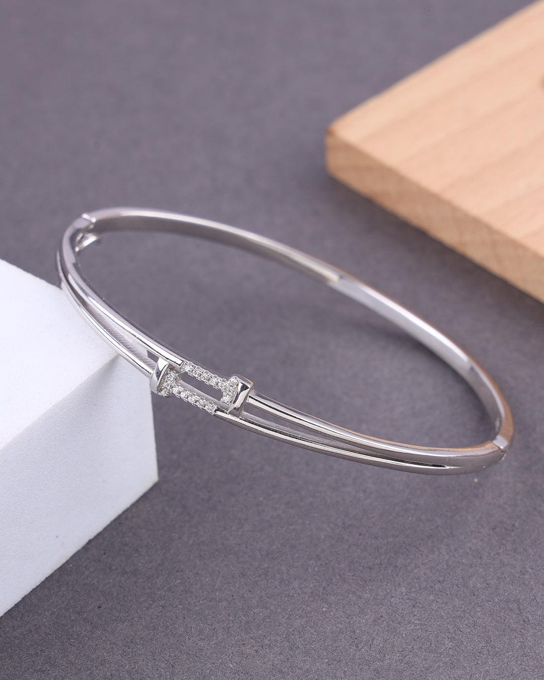 Silver bracelet with a subtle design on a gray surface