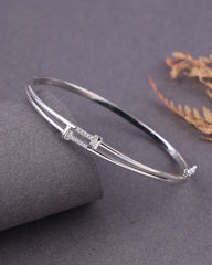 Silver bracelet on a gray surface with a subtle background