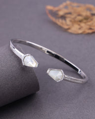 Silver bracelet with gemstone accents on a gray surface