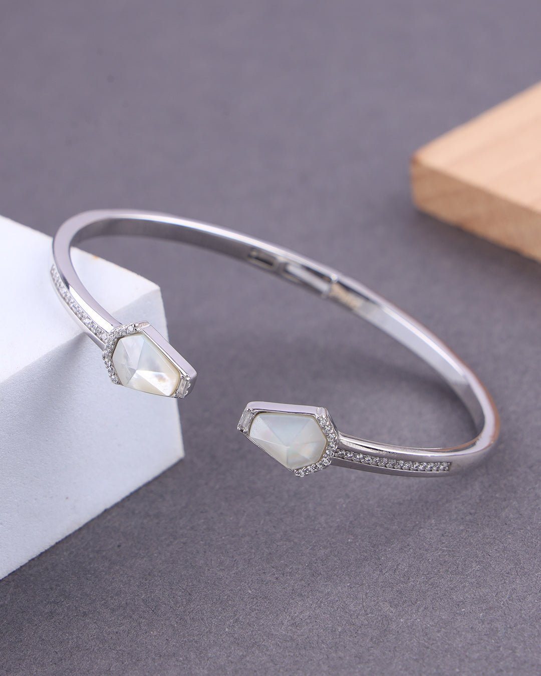 Silver bracelet with gemstones on a gray surface