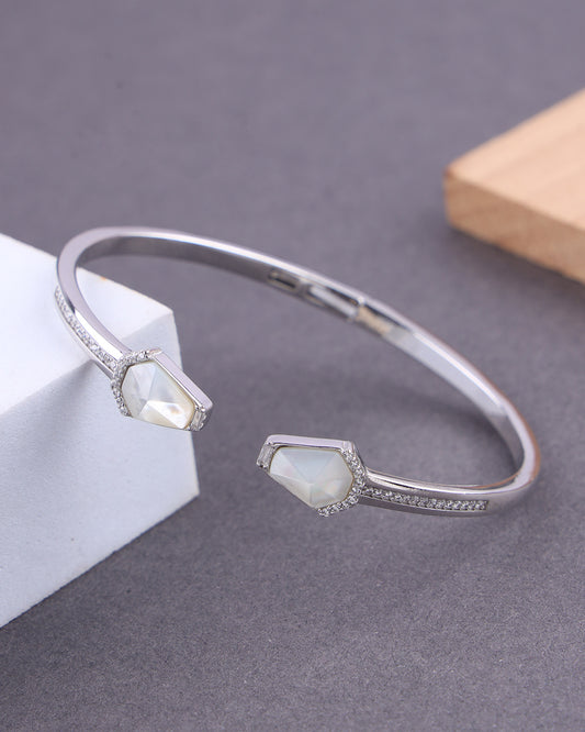 Silver bracelet with gemstones on a gray surface