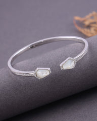Silver bracelet with gemstones on a gray surface