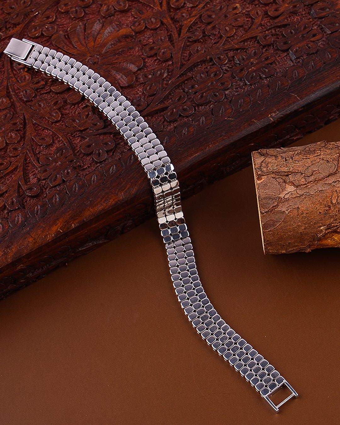 Silver metal bracelet on a textured wooden surface