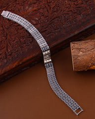 Silver metal bracelet on a textured wooden surface
