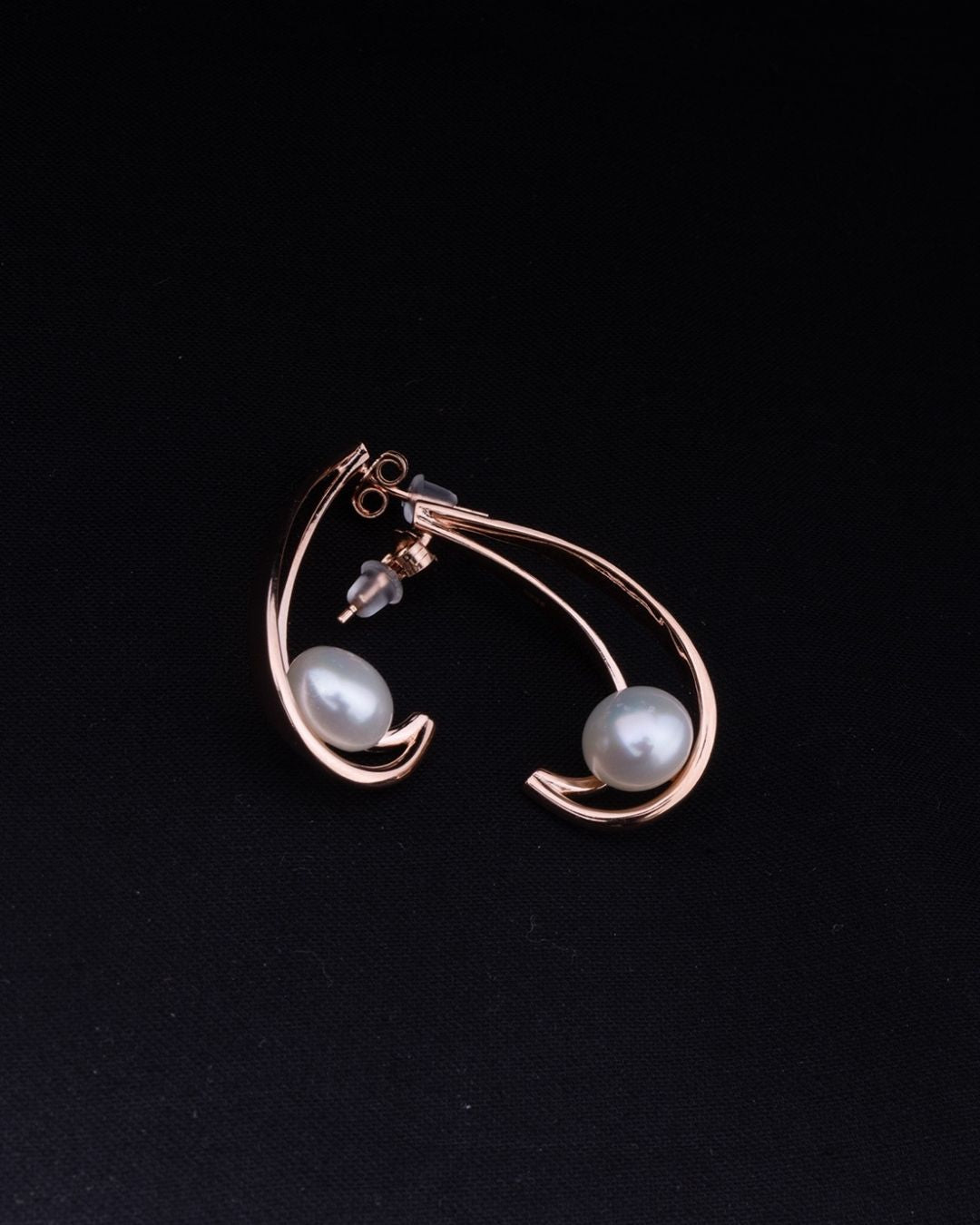 Earring with two pearls on a black background