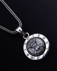 Silver pendant with Roman numeral design on a black background