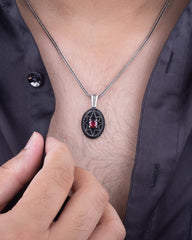 Close-up of a person wearing a necklace with a pendant on a plain background