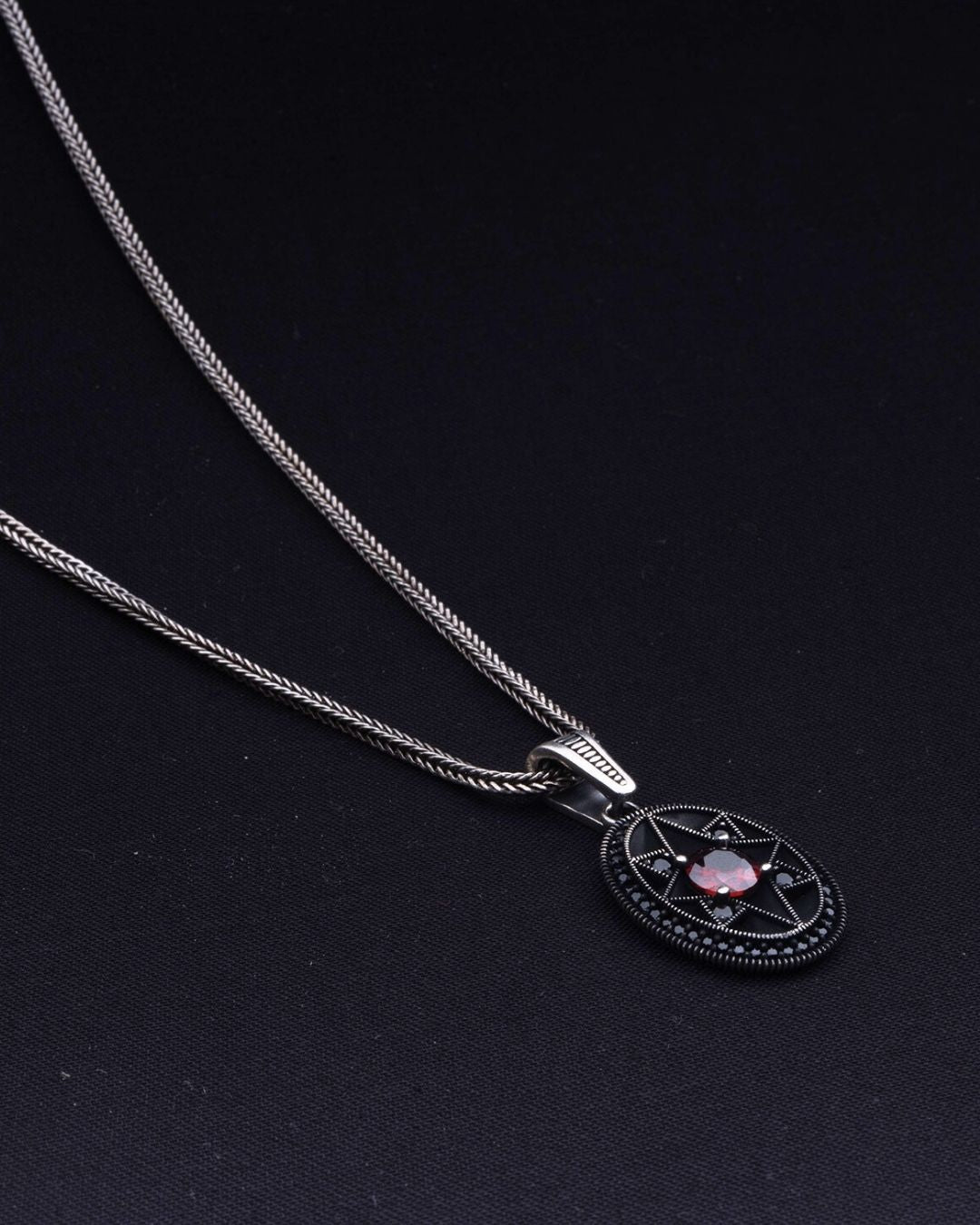 Necklace with a pendant featuring a pink stone on a black background