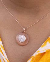 925 Sterling silver Necklace with a round pendant featuring a rose gold border and diamond-like stones, worn by a person.