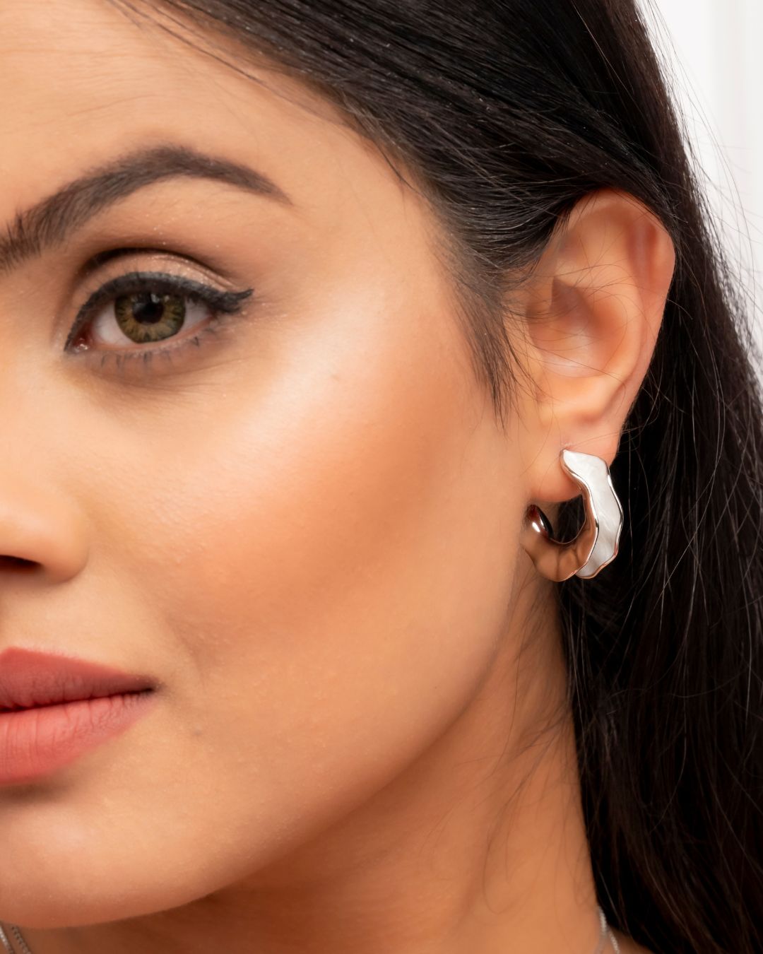 Close-up of a woman wearing a silver earring.