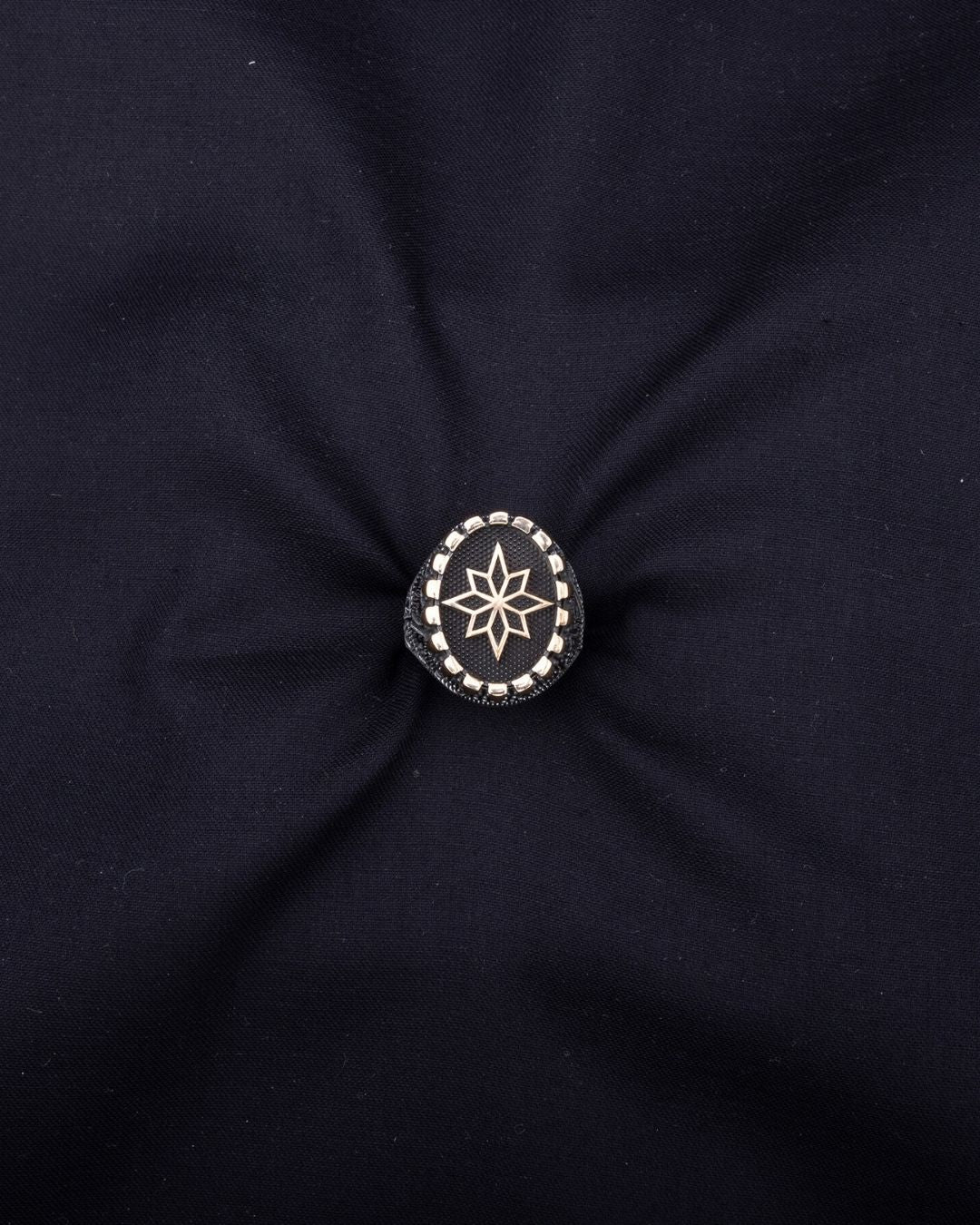 Black fabric with a knotted center and star design brooch