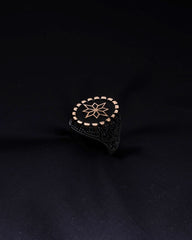 Black ring with gold star design on a black background