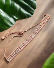 Rose gold bracelet with diamonds on a wooden surface with green leaves