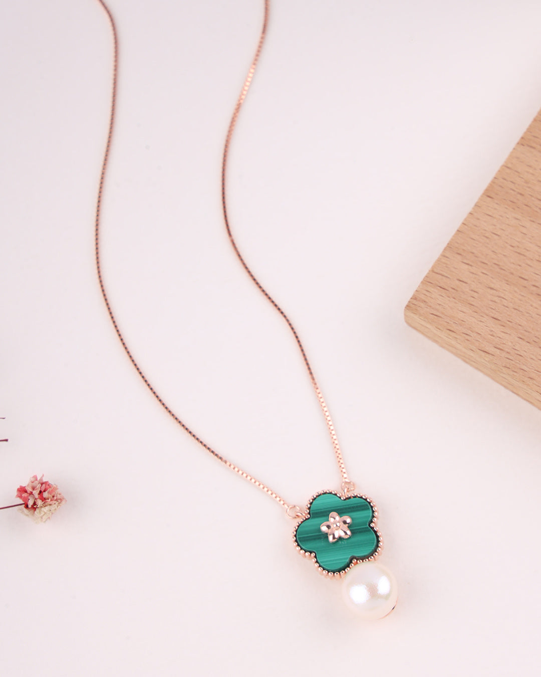 Necklace with a green flower pendant on a light background