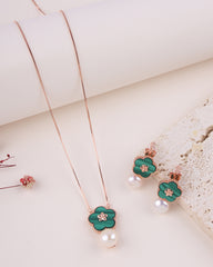Jewelry set with green floral pendant necklace and earrings on a light background