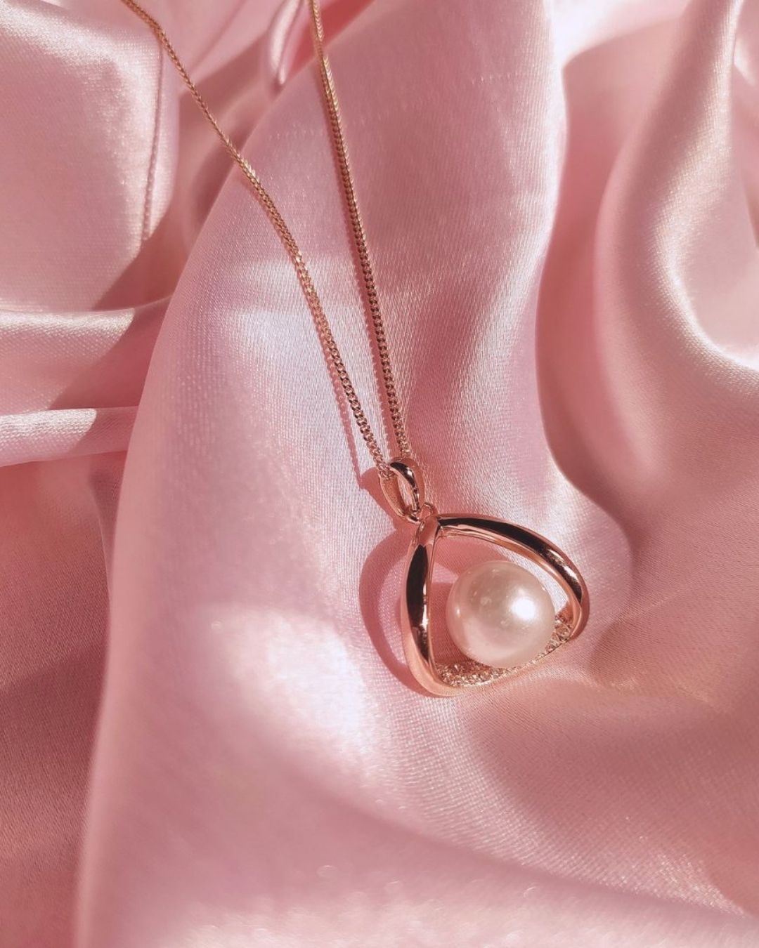 Pearl necklace on a pink satin background