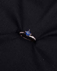 Ring with a blue gemstone on a black fabric background