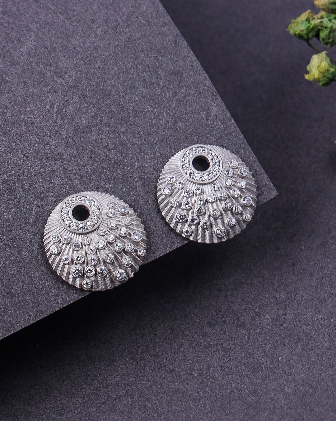 Pair of silver earrings on a dark gray surface
