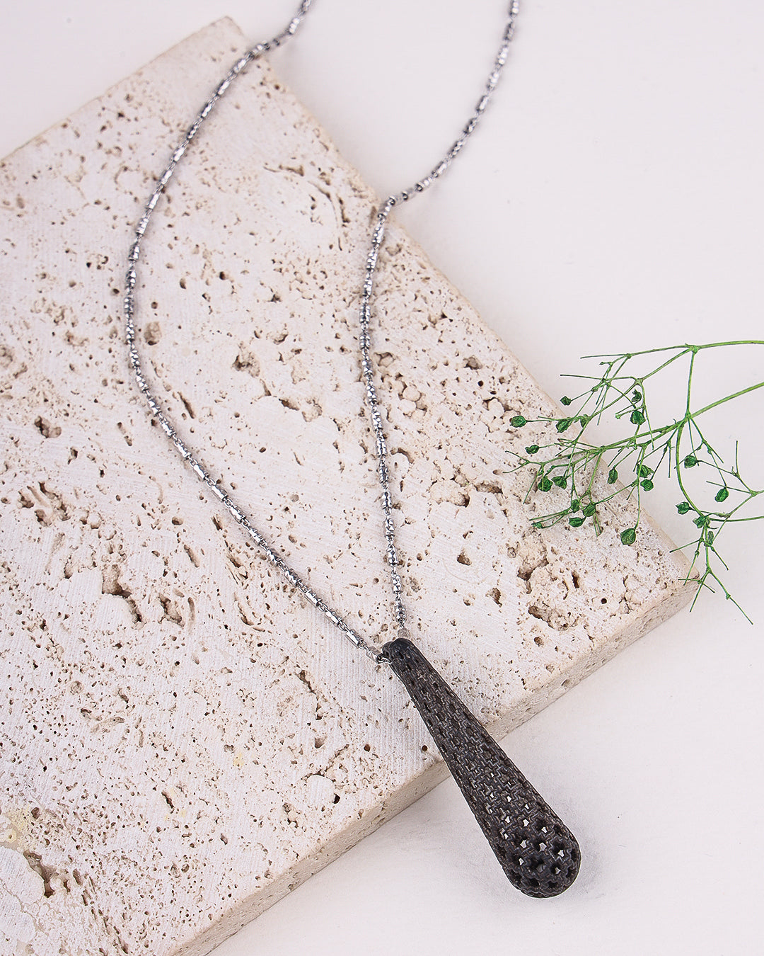 Necklace with a textured pendant on a stone surface