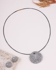 Silver necklace with decorative pendants on a light background