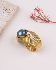 Gold ring with a blue gemstone on a light background