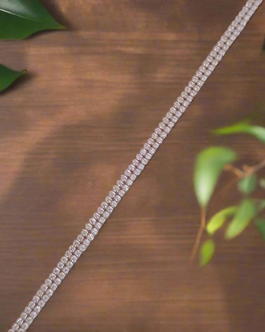 Sterling Silver Bracelet on a wooden surface with green leaves in the background