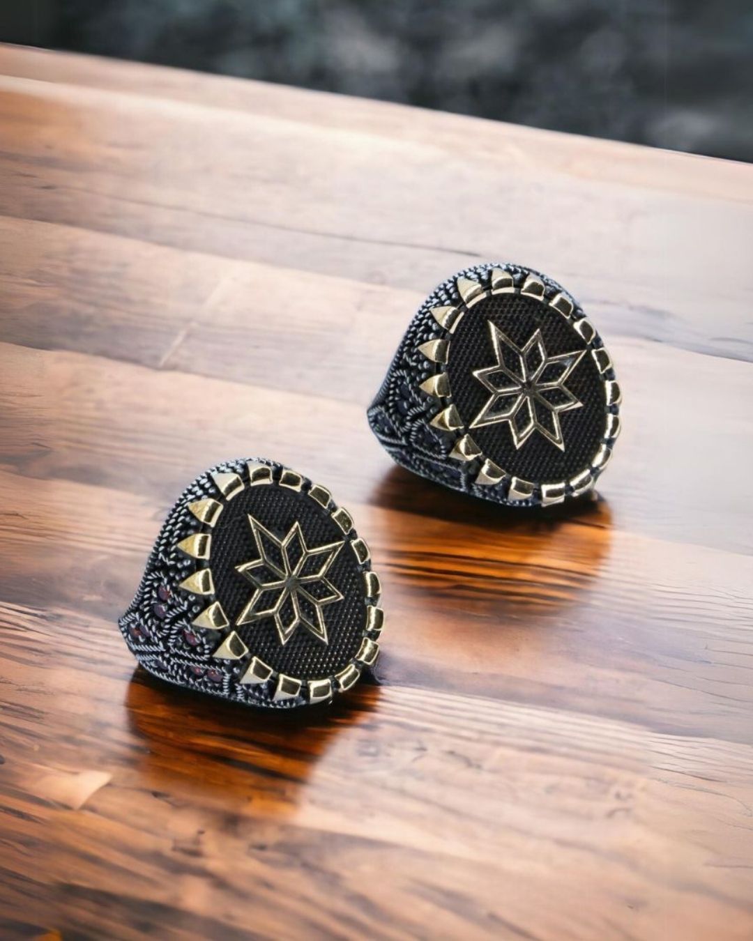 Two black and gold patterned objects on a wooden surface