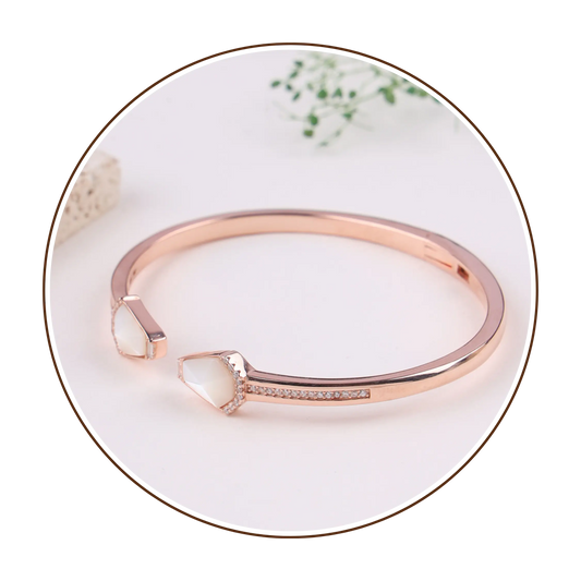 Rose gold bracelet with a white stone on a decorative plate