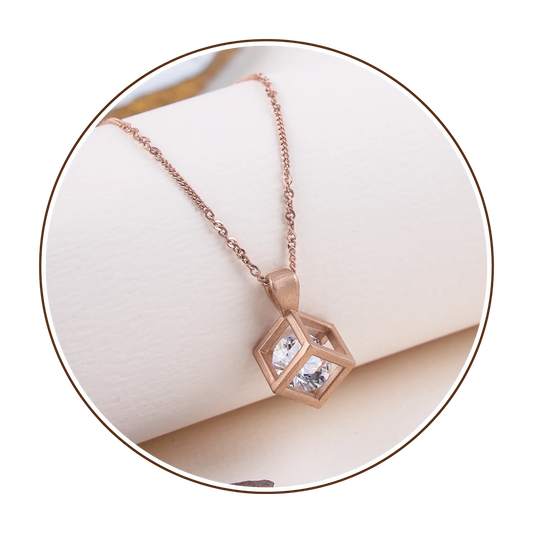 Rose gold necklace with a hexagonal pendant on a white background