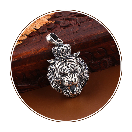 Silver lion pendant with a crown on a wooden surface